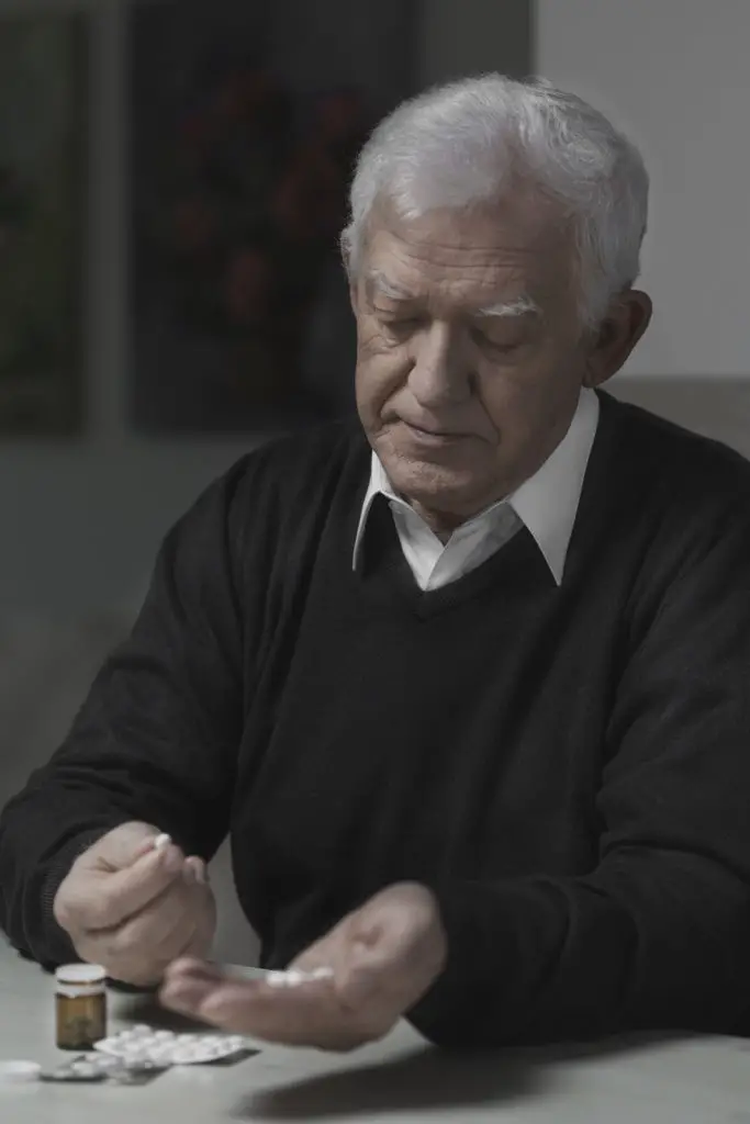 A senior man takes medication.