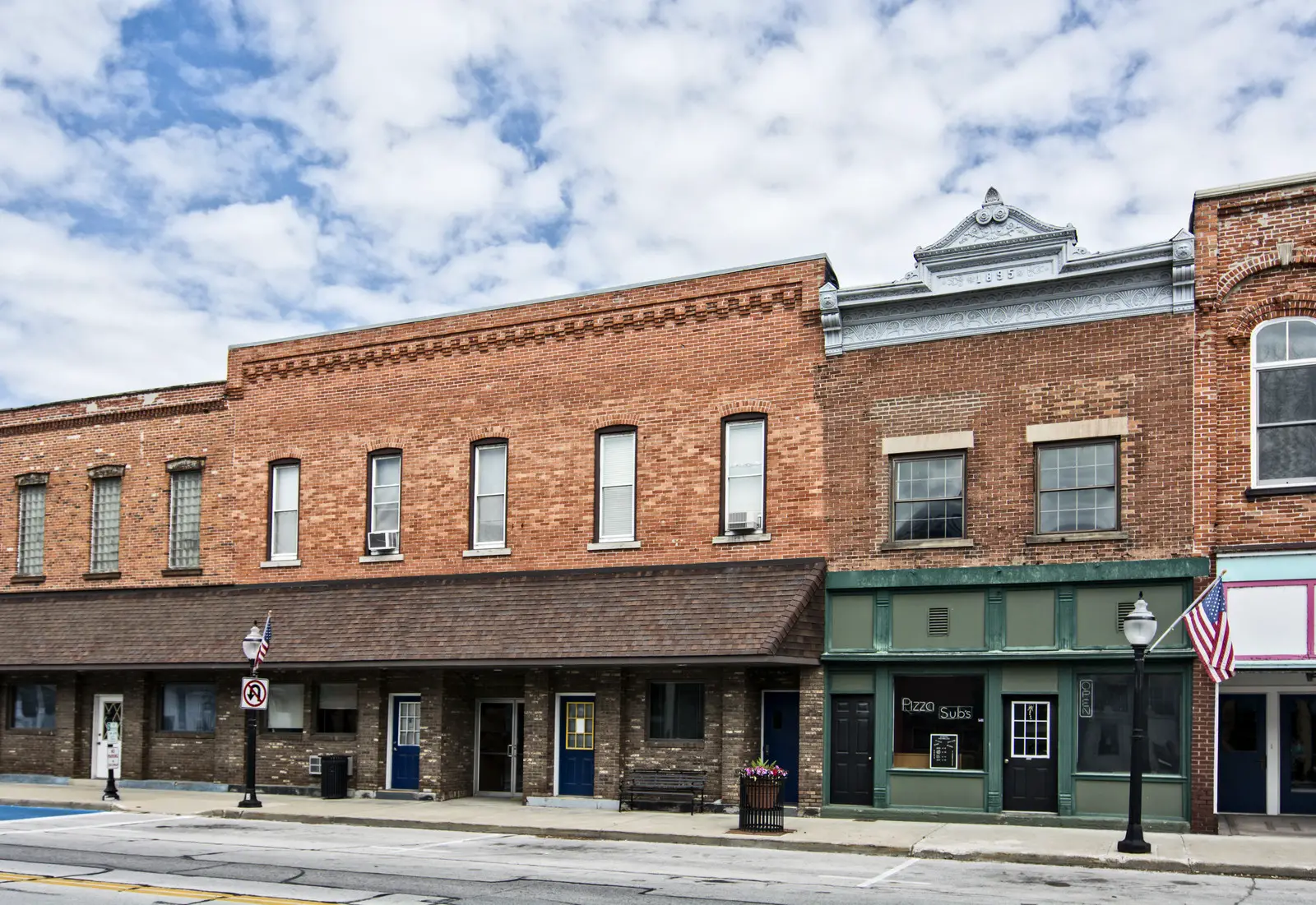 Small town main street with old brick store fronts - Blue sky with white billowy clouds