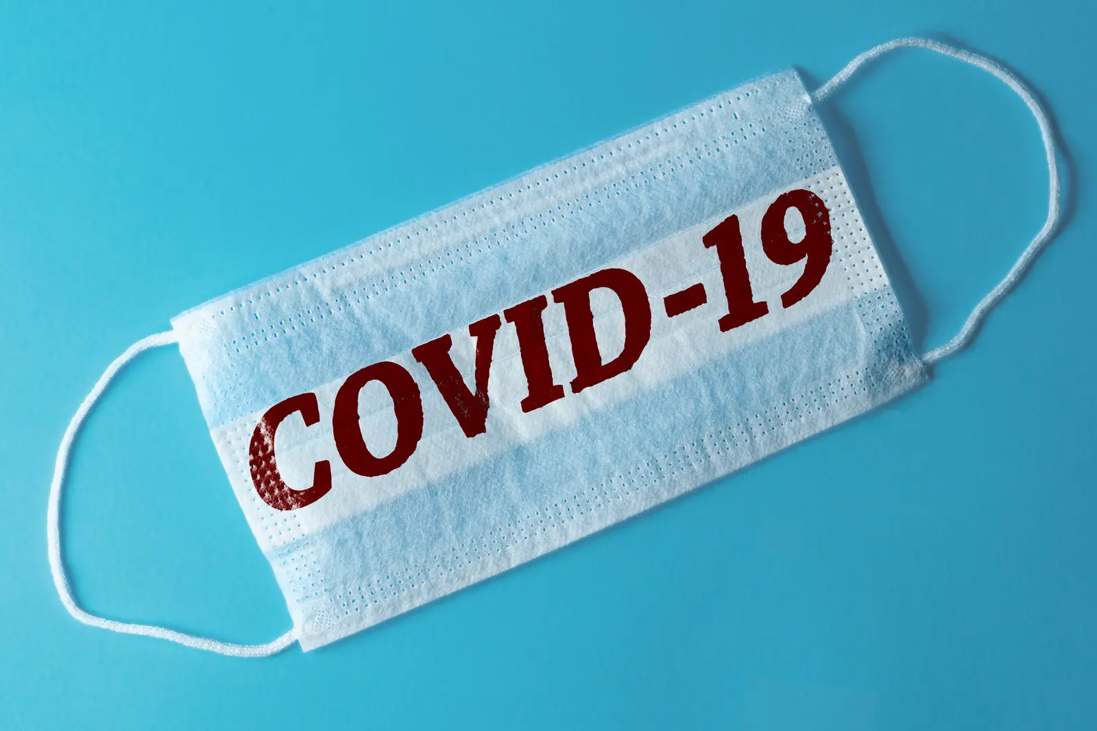Face mask that says COVID-19 across it in red