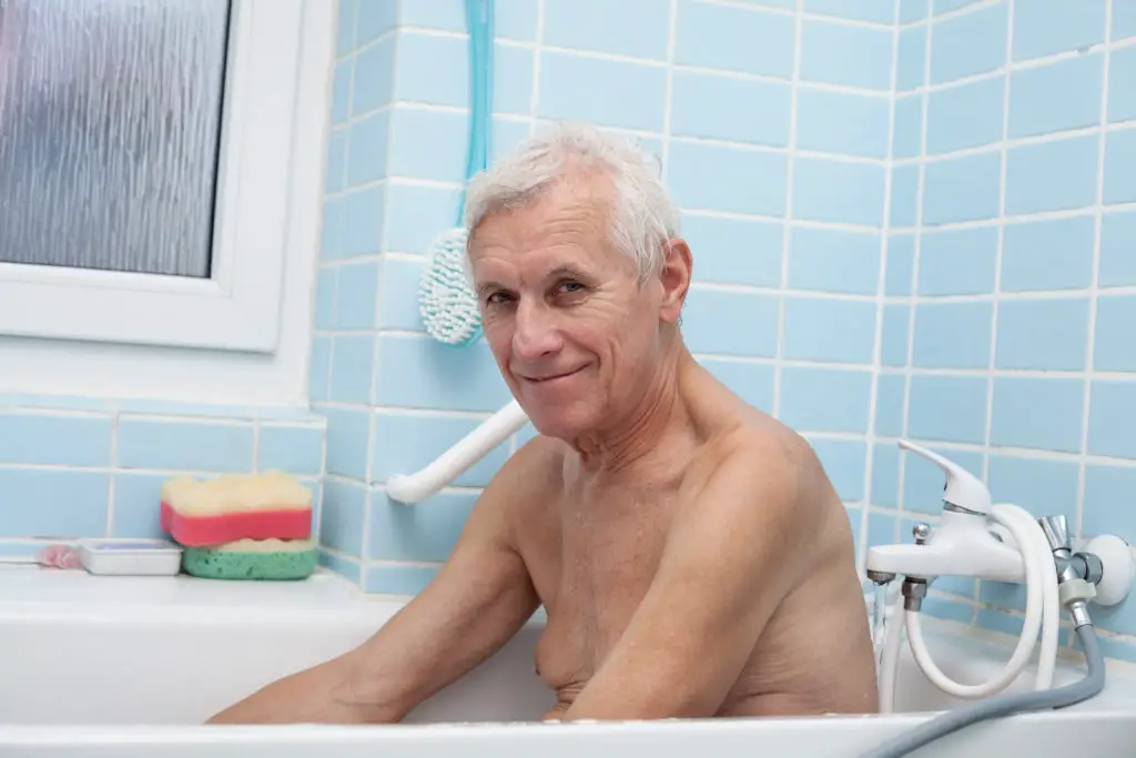 A senior man takes a bath. 