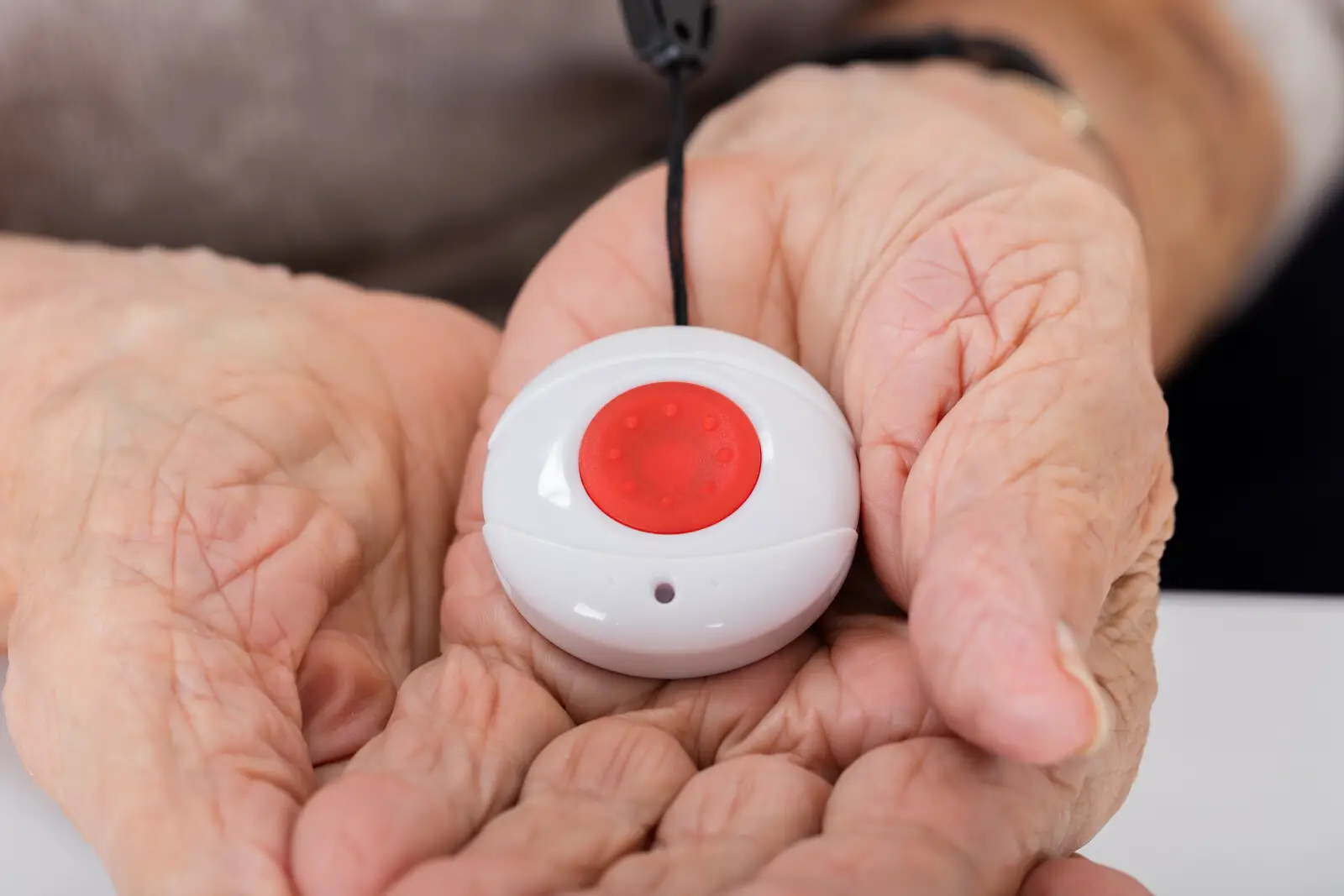 senior woman holding a medical alert button in her hand
