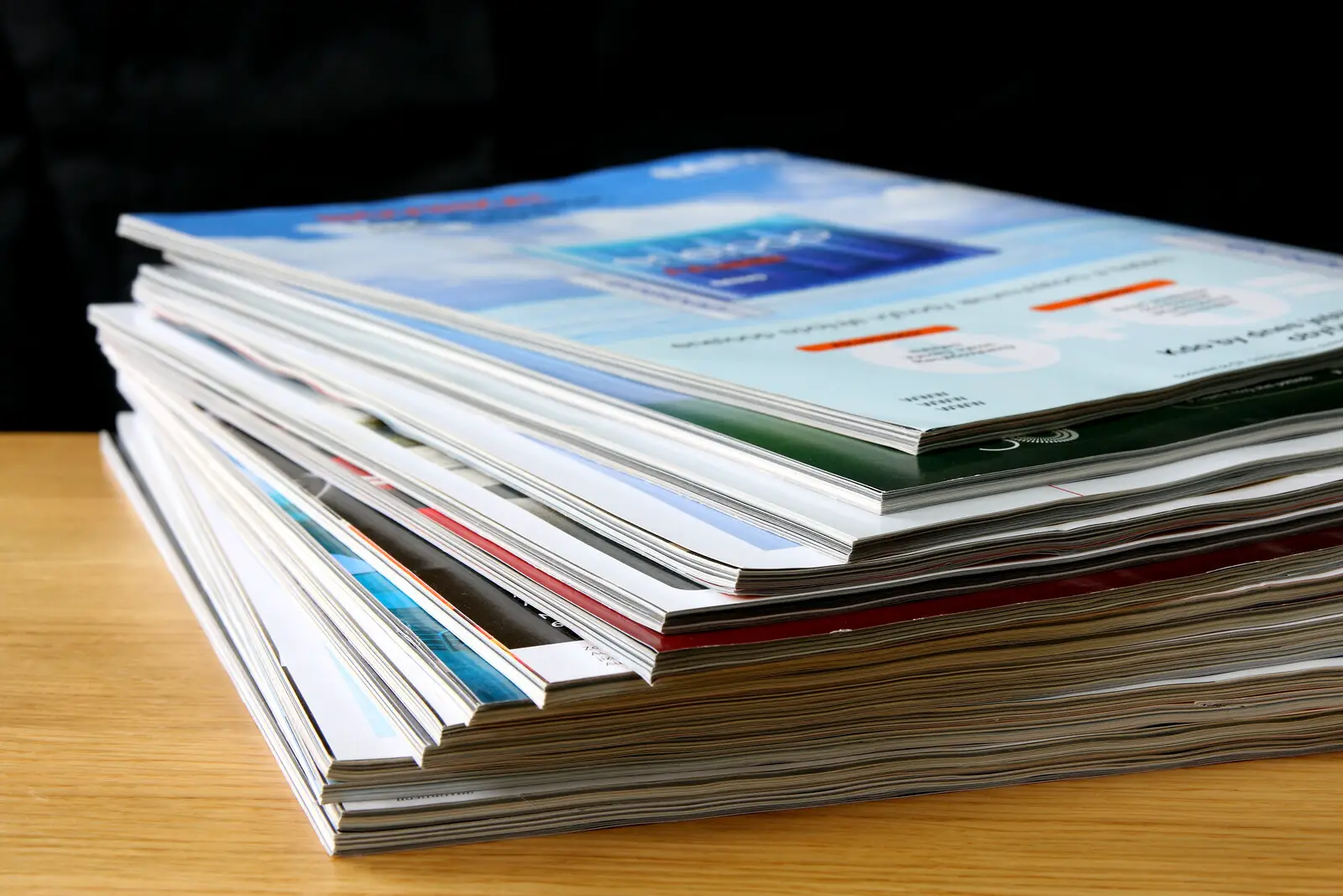 stack of magazines on a wooden table 
